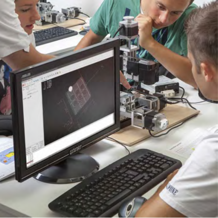 CNC Makerspace with computers and 4 axis milling on a table in a classroom