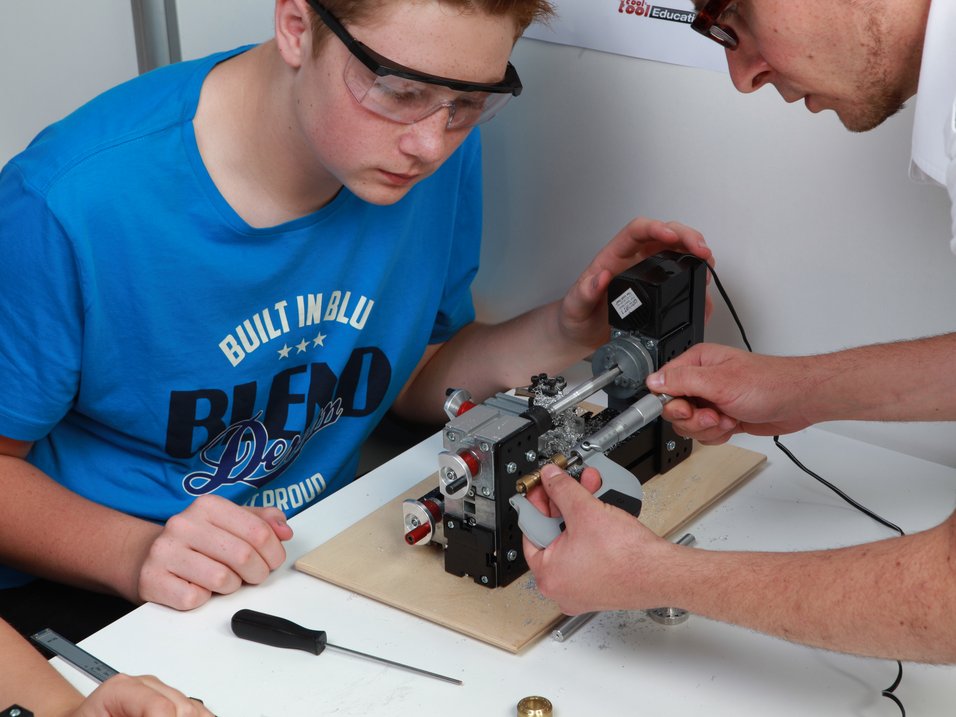 UNIMAT technic set in the classroom, teachers is measuring a workspiece together with a student