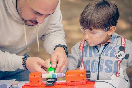 child with father working with playmake